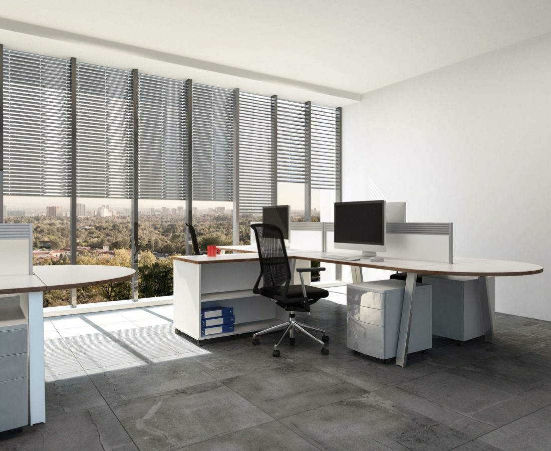 Modern open plan office with large windows and multi seat workstations around table style desks